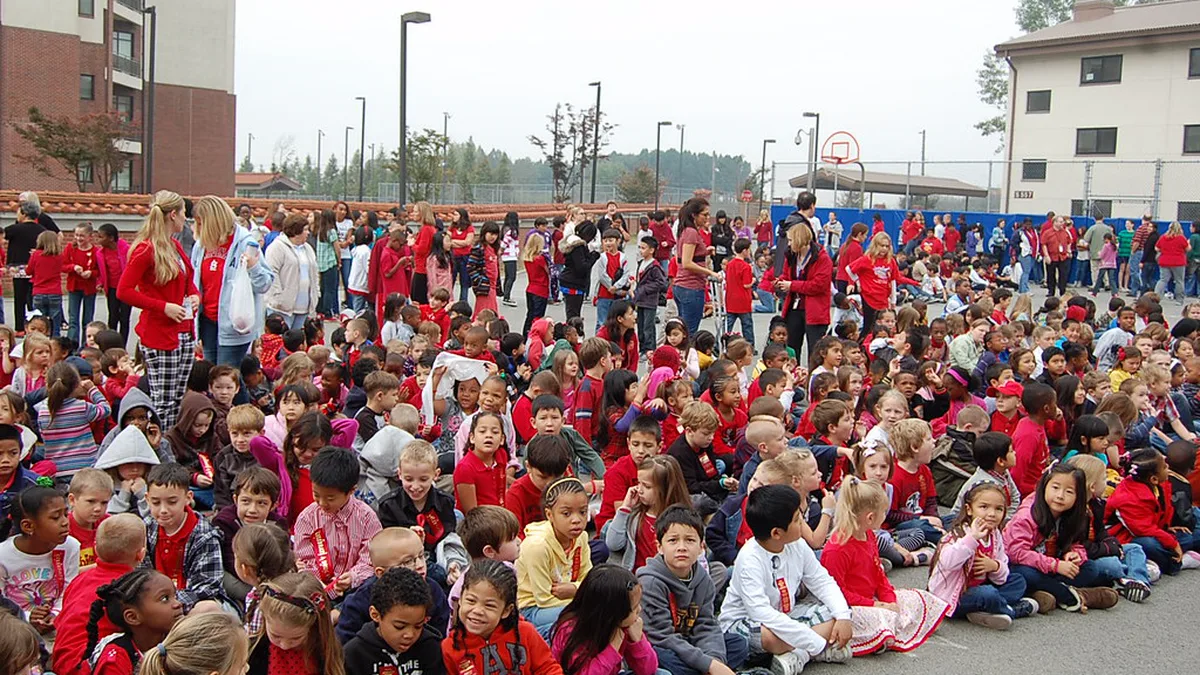 School Crowd Wearing Red at a Red Ribbon Week Opening Ceremony Large crowd of students and teachers wearing red seated on a school blacktop for a Red Ribbon Week opening ceremony
