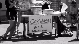 Hand lettered car wash sign reading 10 am to 2 pm for donations only on a folding table, a common student council fundraiser idea