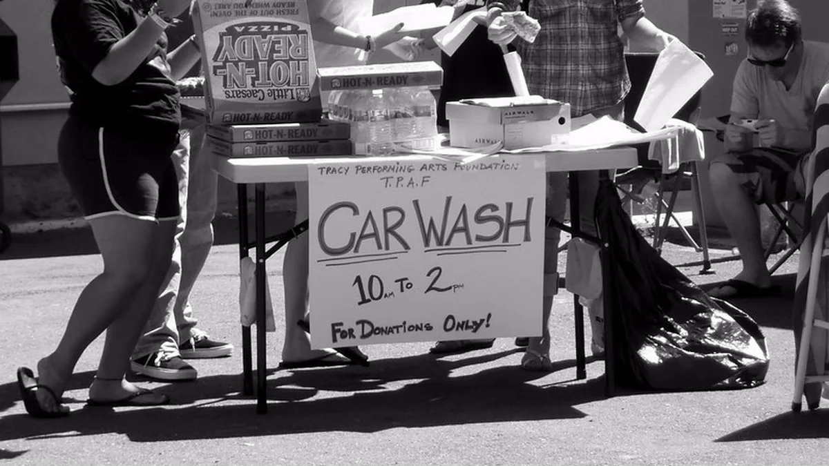 Car Wash Donation Sign Taped to a Fundraiser Table Hand lettered car wash sign reading 10 am to 2 pm for donations only on a folding table, a common student council fundraiser idea